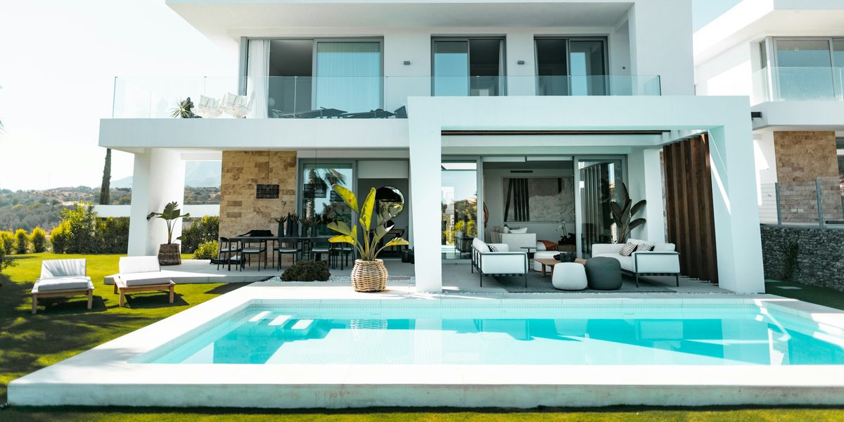 Betonpool im Garten eines Chalets auf Mallorca mit hellen Beckenrandsteinen und Sonnenterrasse am Haus