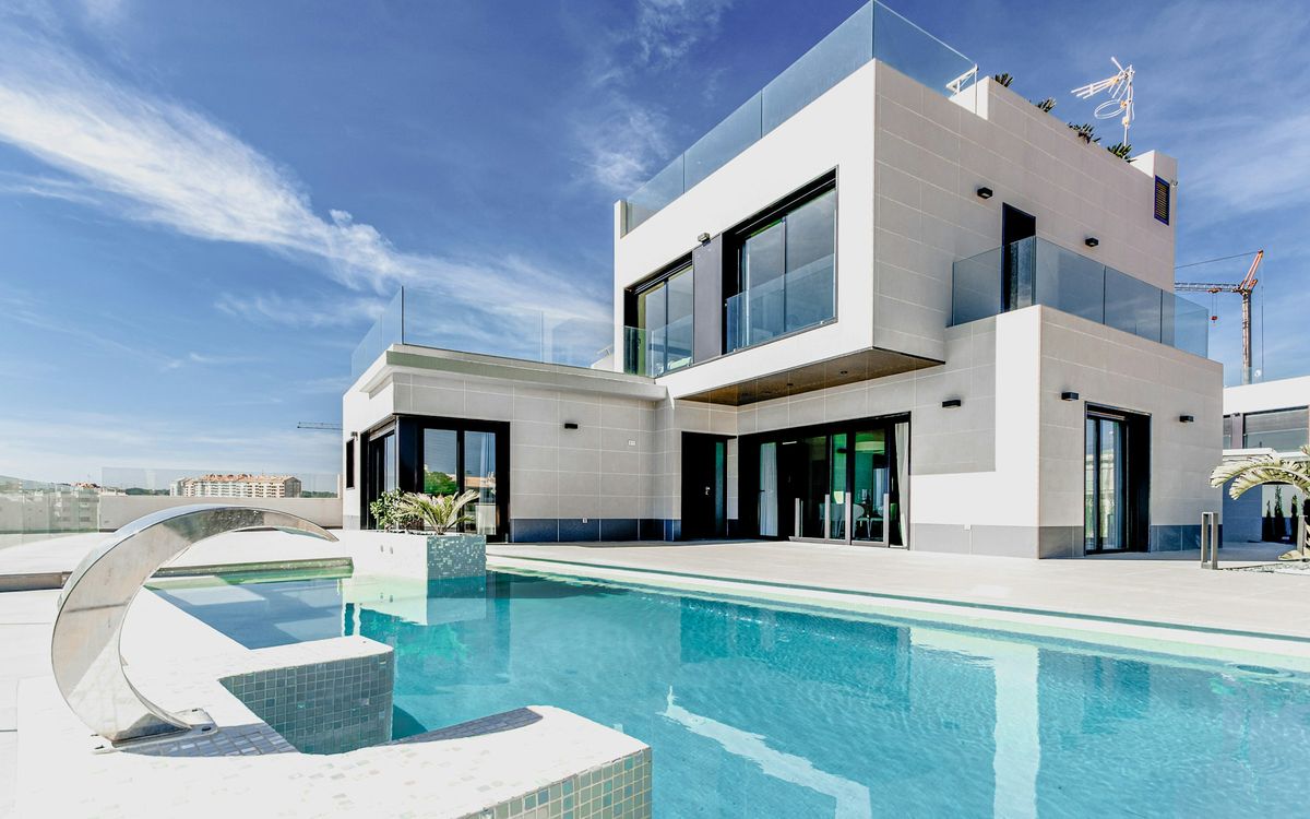 Renovated villa in Mallorca seen from the garden: white façade, large windows and swimming pool