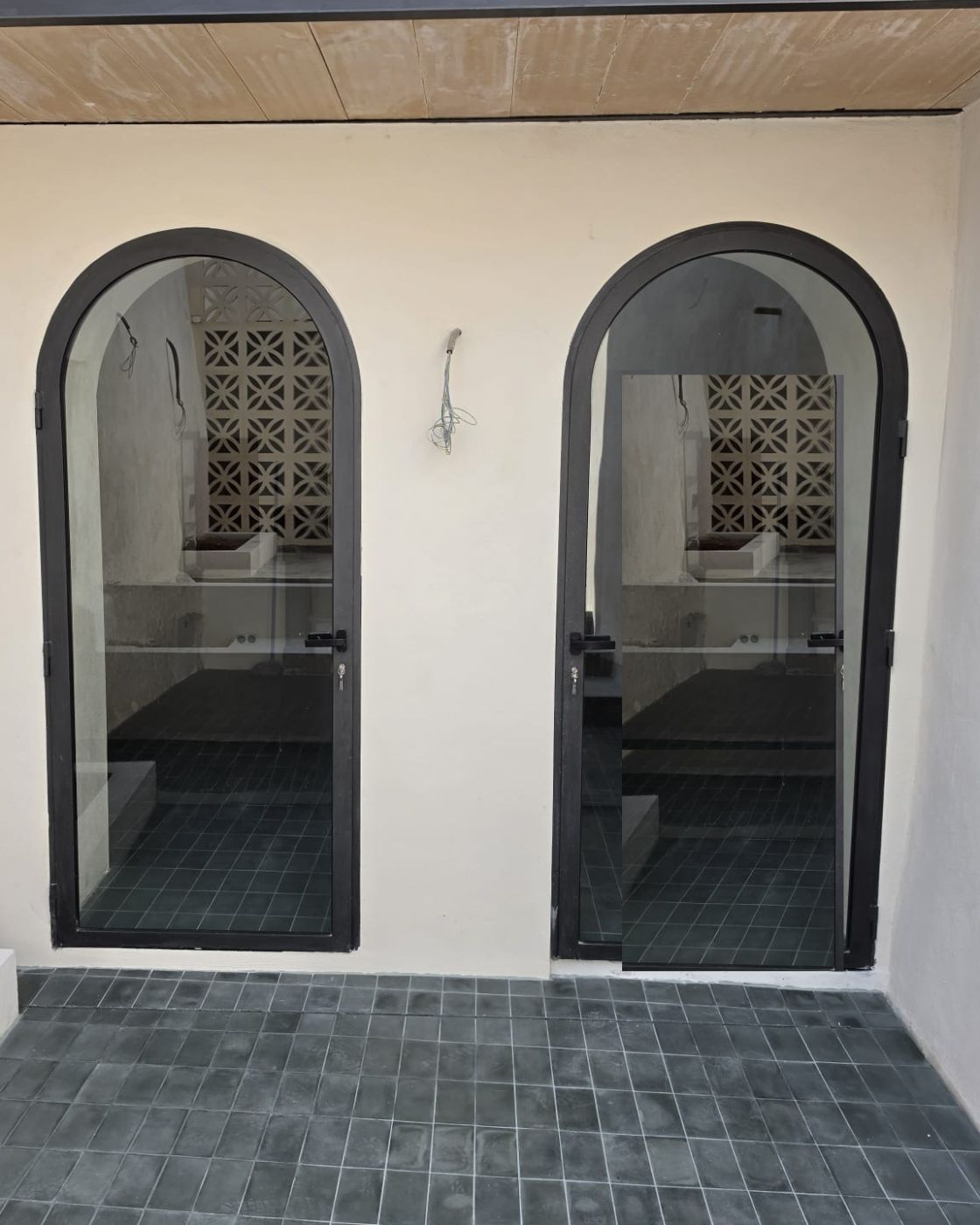 Arched aluminium doors and tiled flooring in a renovation in Sineu